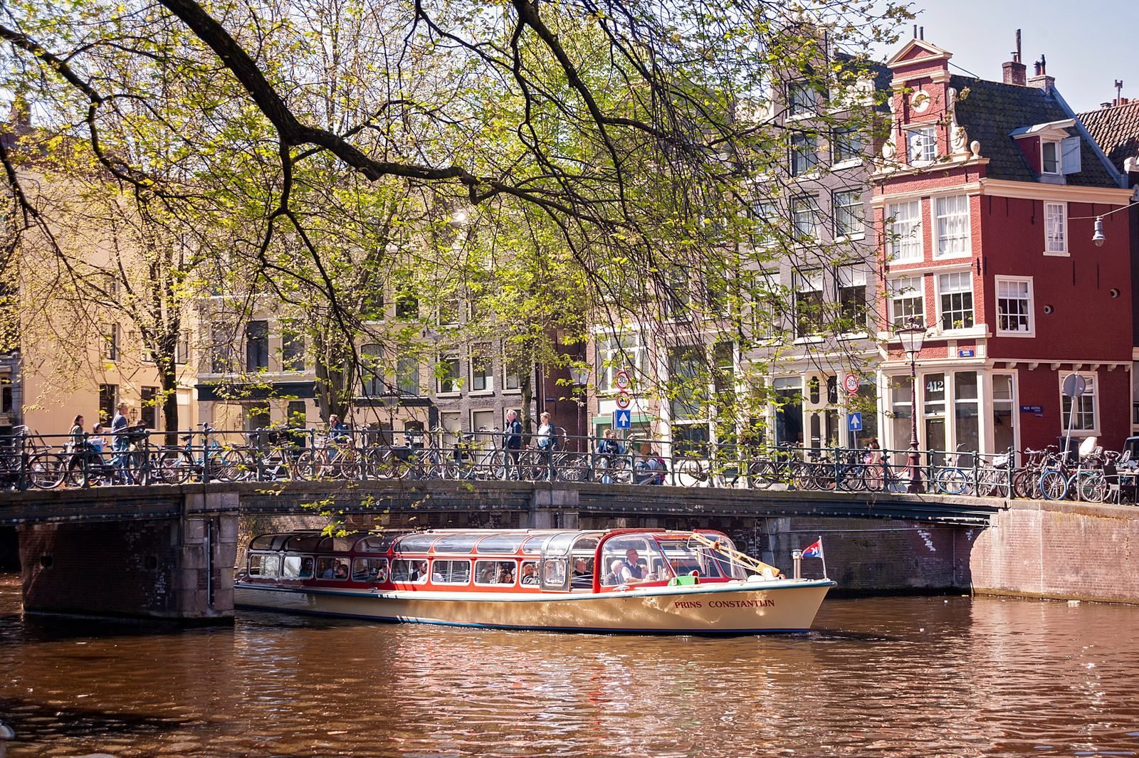 Tour boat passing under a classic Amsterdam bridge