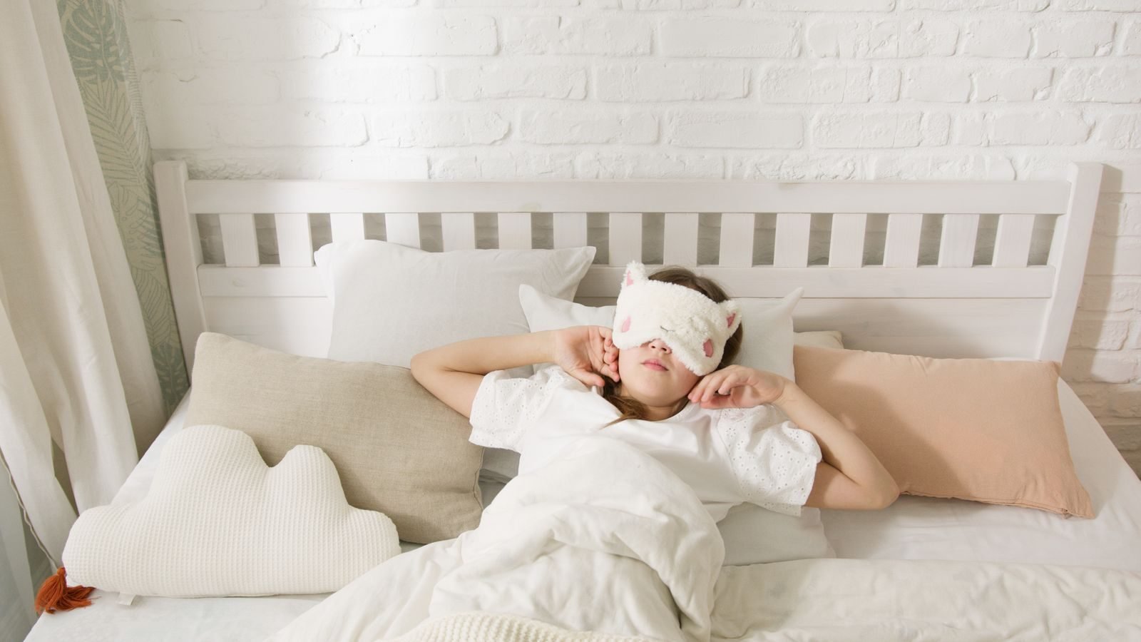 Persona descansando en la cama con un antifaz para dormir