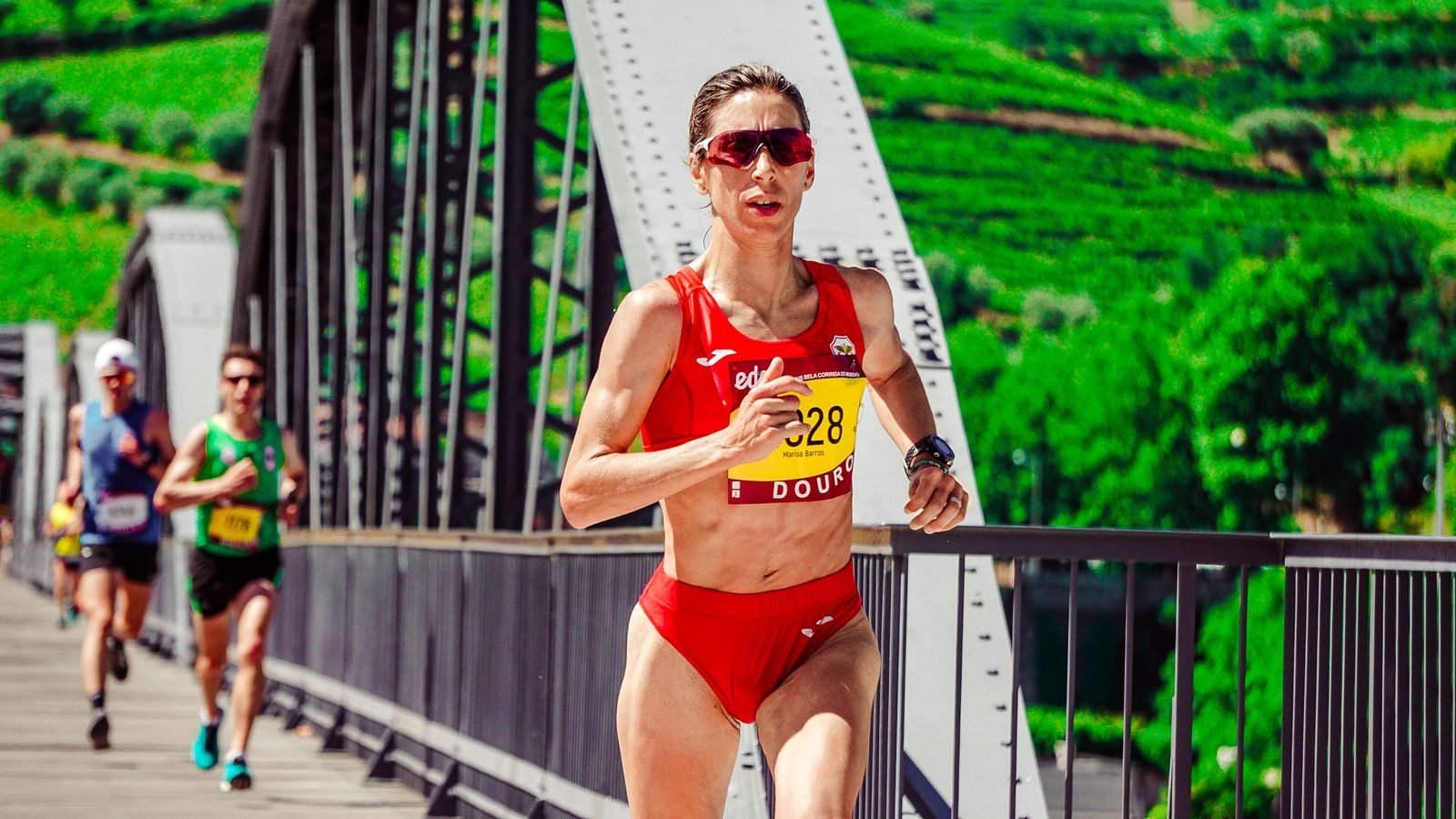 Focused athlete running a marathon across a bridge