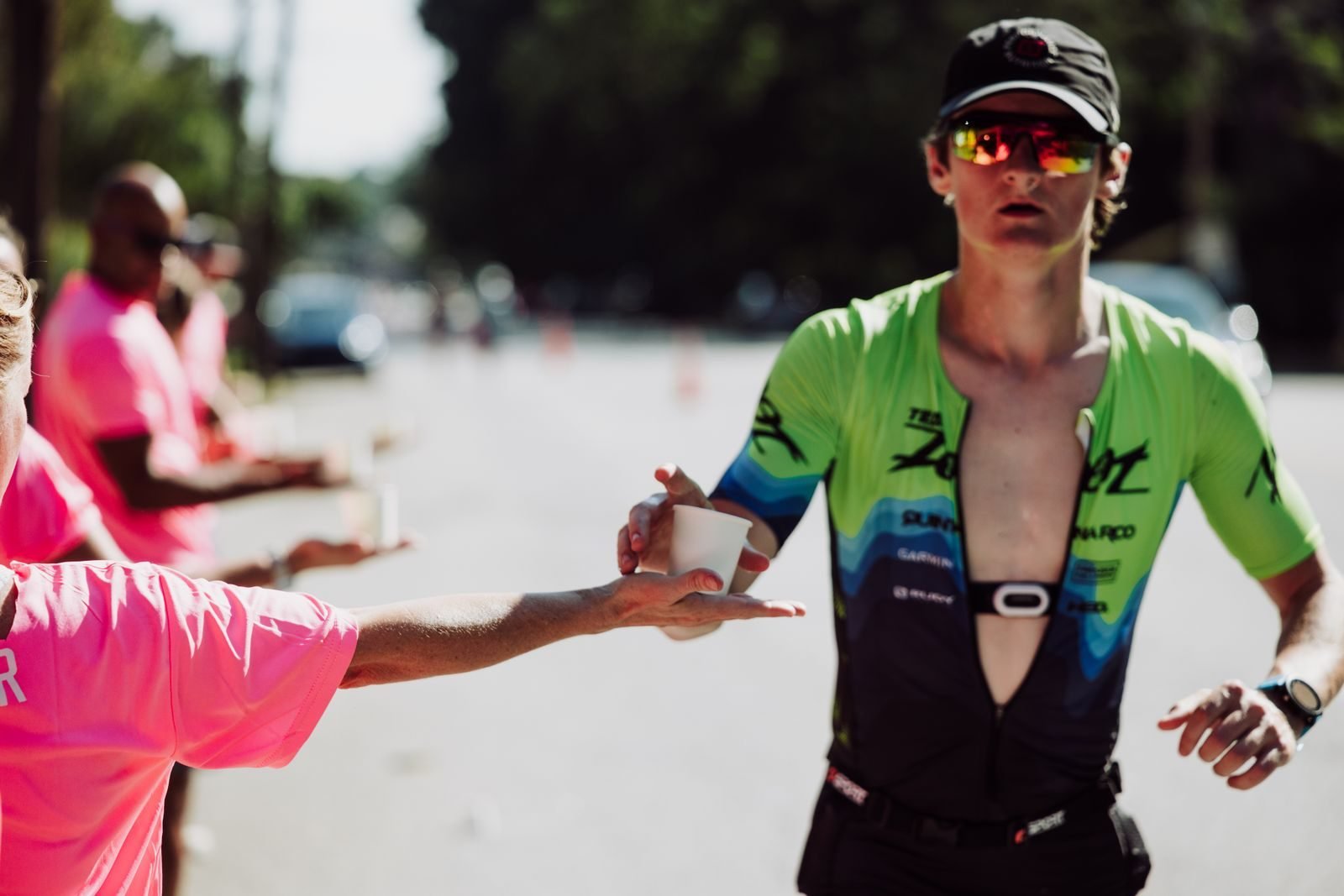 Corredor recogiendo un vaso de agua en un avituallamiento de maratón