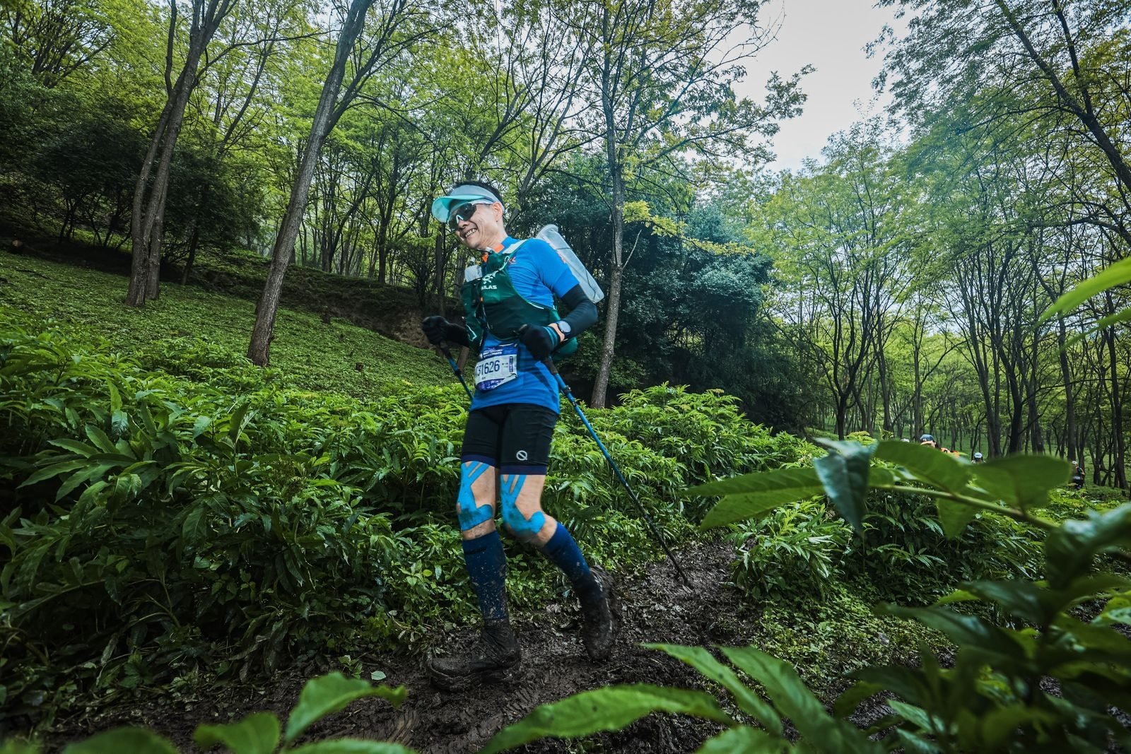 Atleta corriendo por un sendero del bosque en carrera, como al correr cuesta abajo