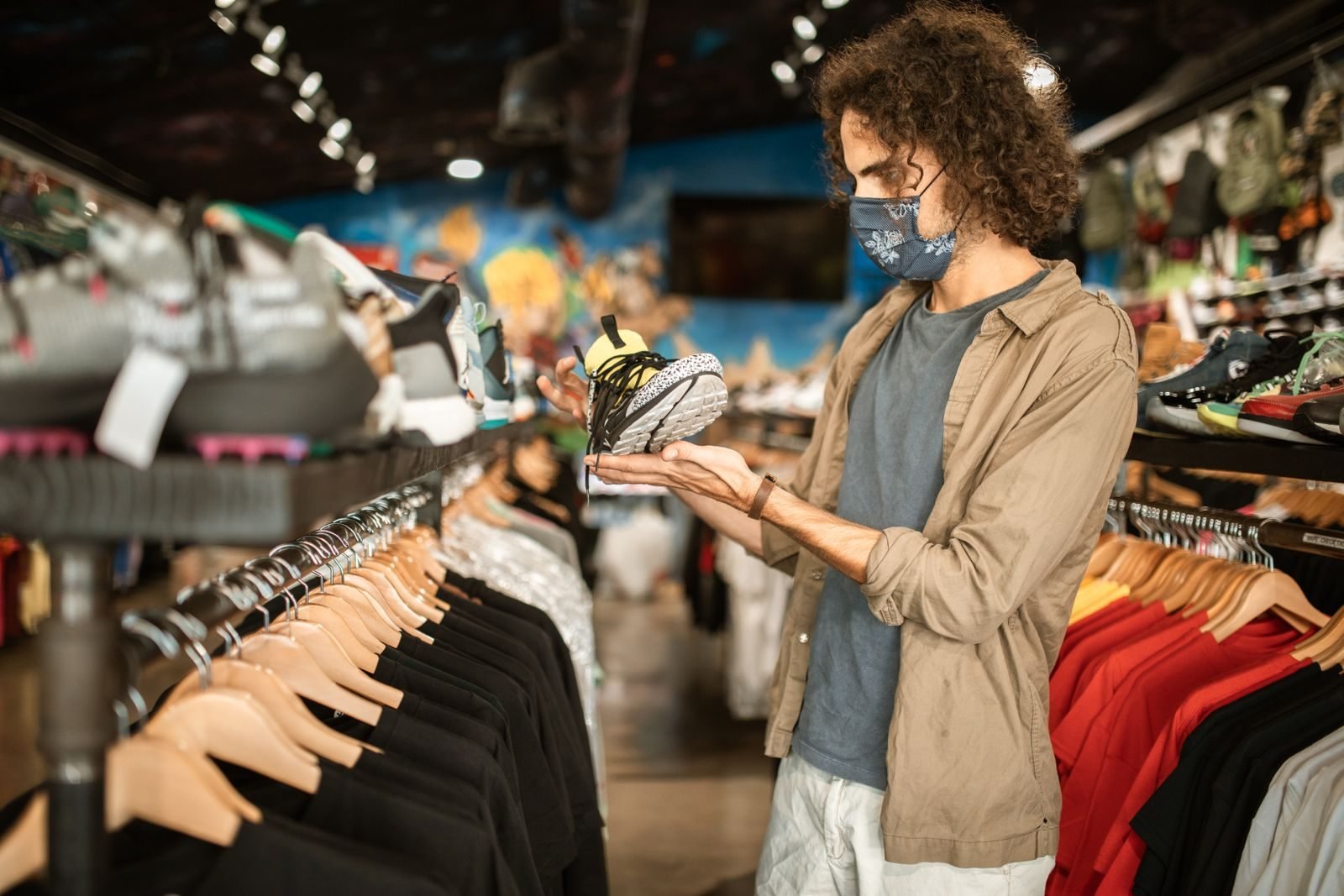 Man checking sneakers in a store before choosing his size