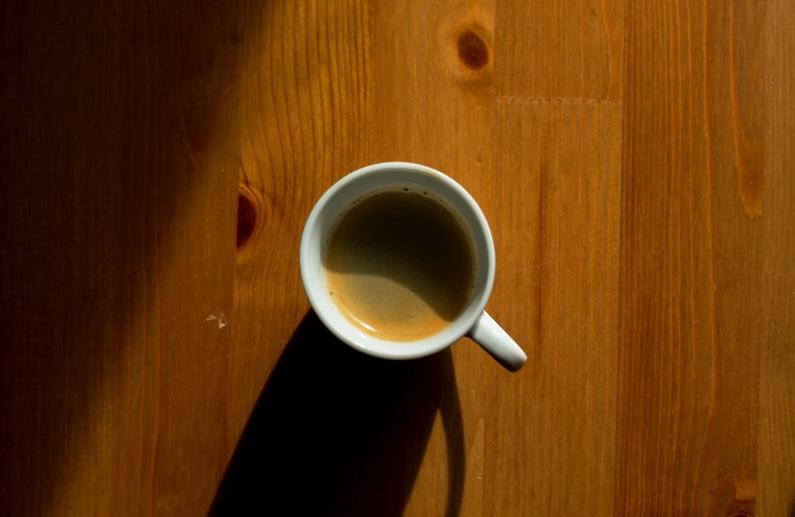Taza de café sobre una mesa de madera, una fuente de cafeína para correr