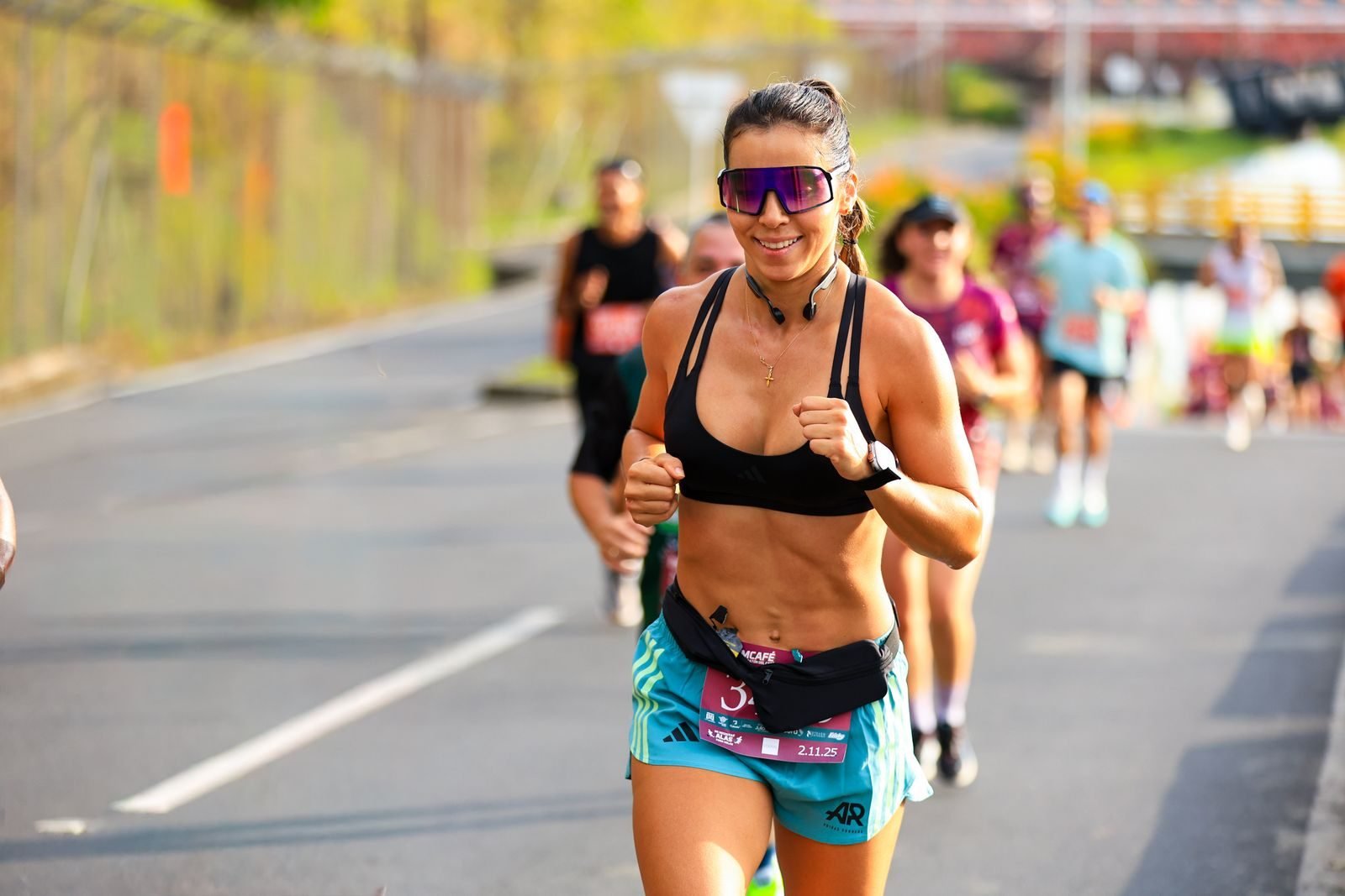 Corredora en una carrera popular quemando calorías corriendo bajo el sol
