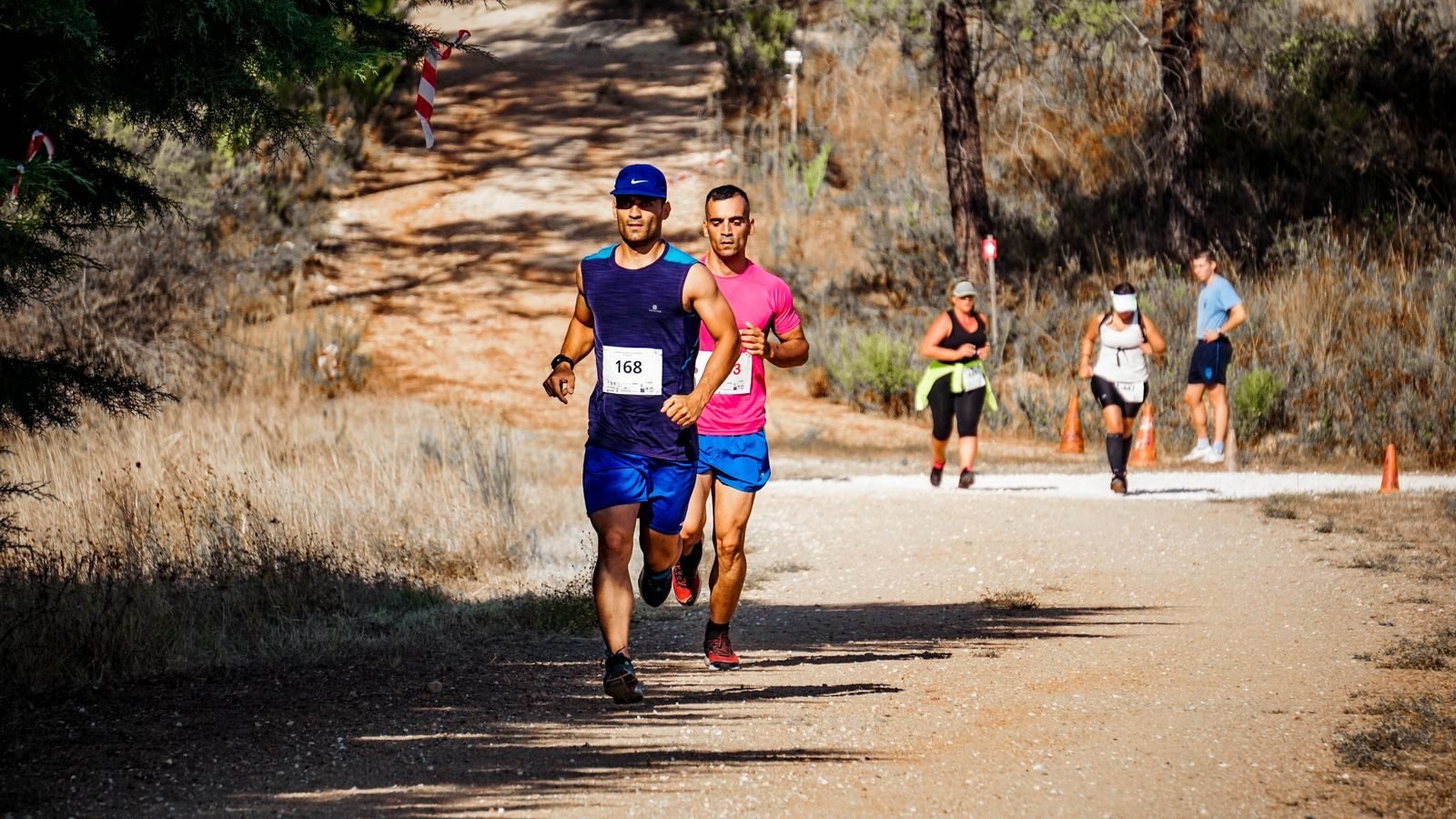 Corredores en una carrera por una pista de tierra entre árboles, donde se pone a prueba la durabilidad