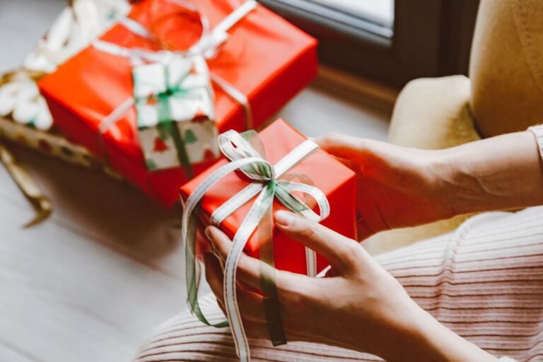 Hands holding a wrapped Christmas gift, cheap gifts for runners