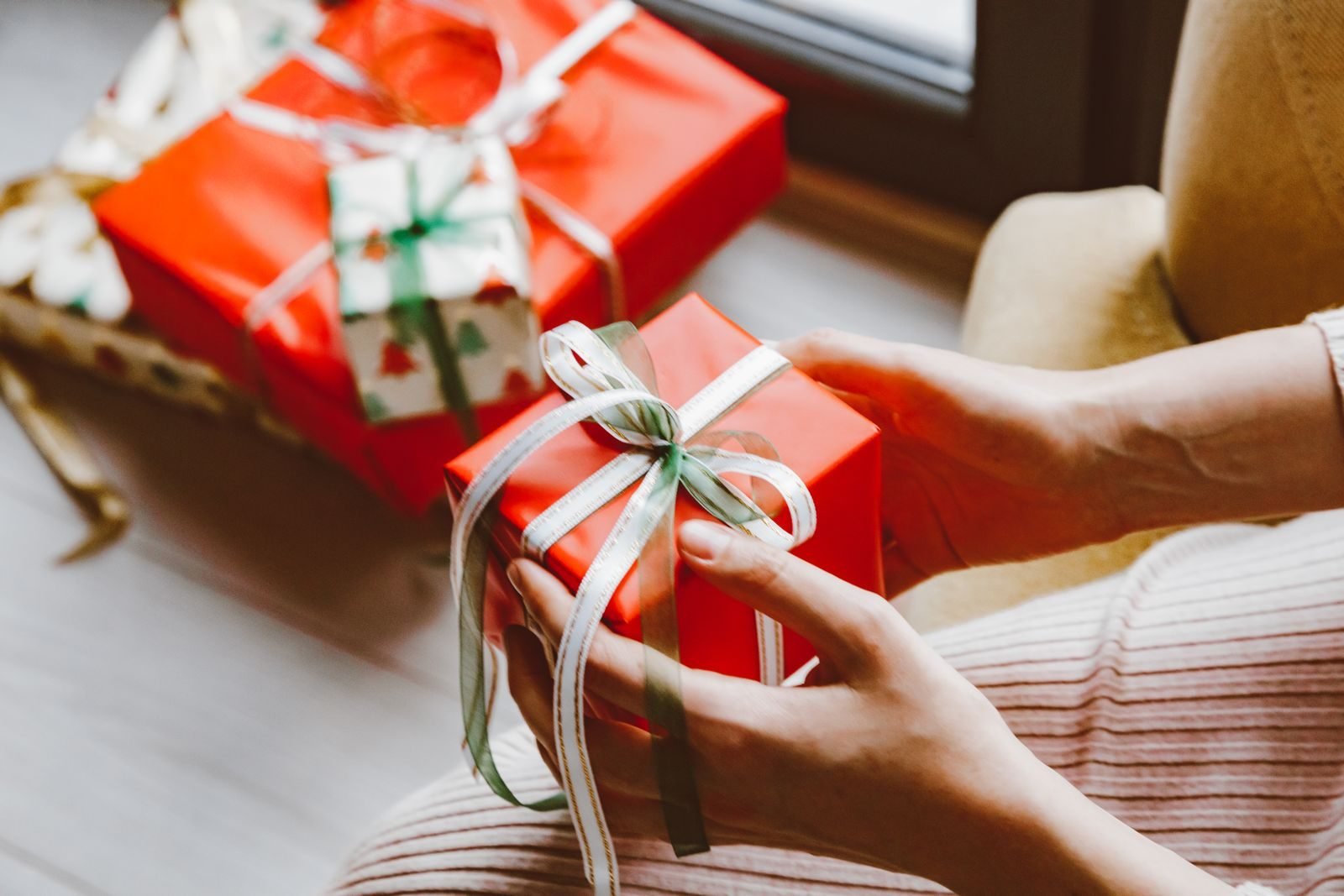 Hands holding a wrapped Christmas gift, cheap gifts for runners
