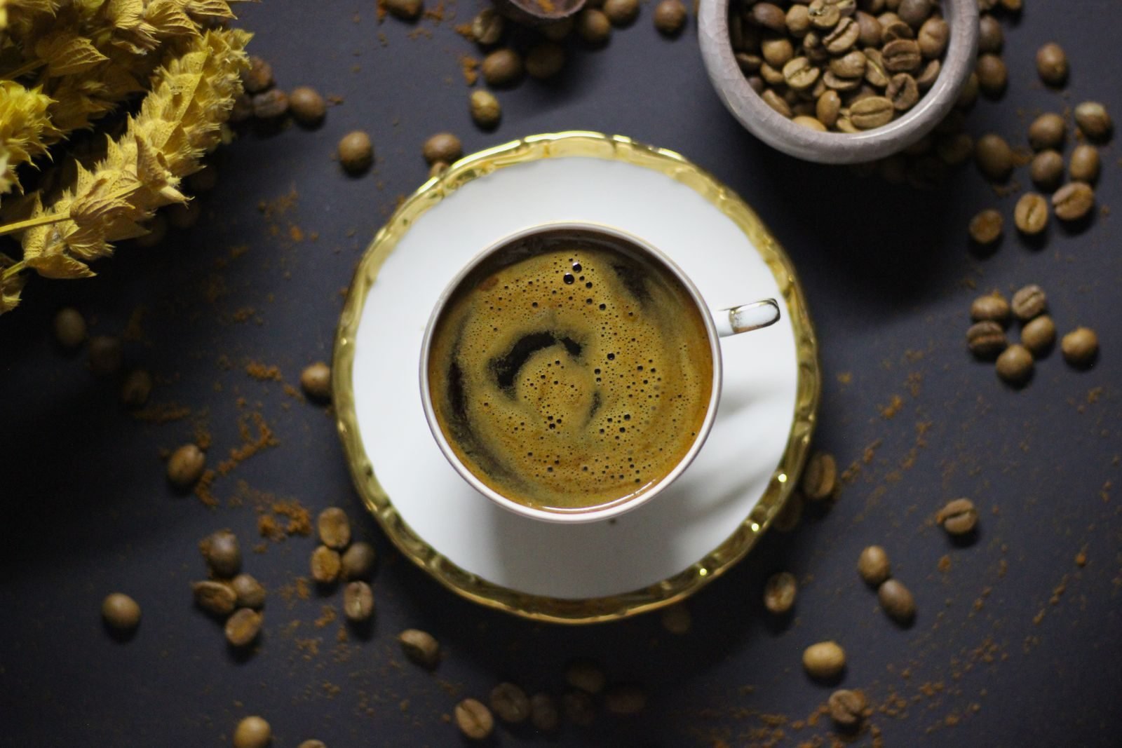 Cup of coffee surrounded by coffee beans