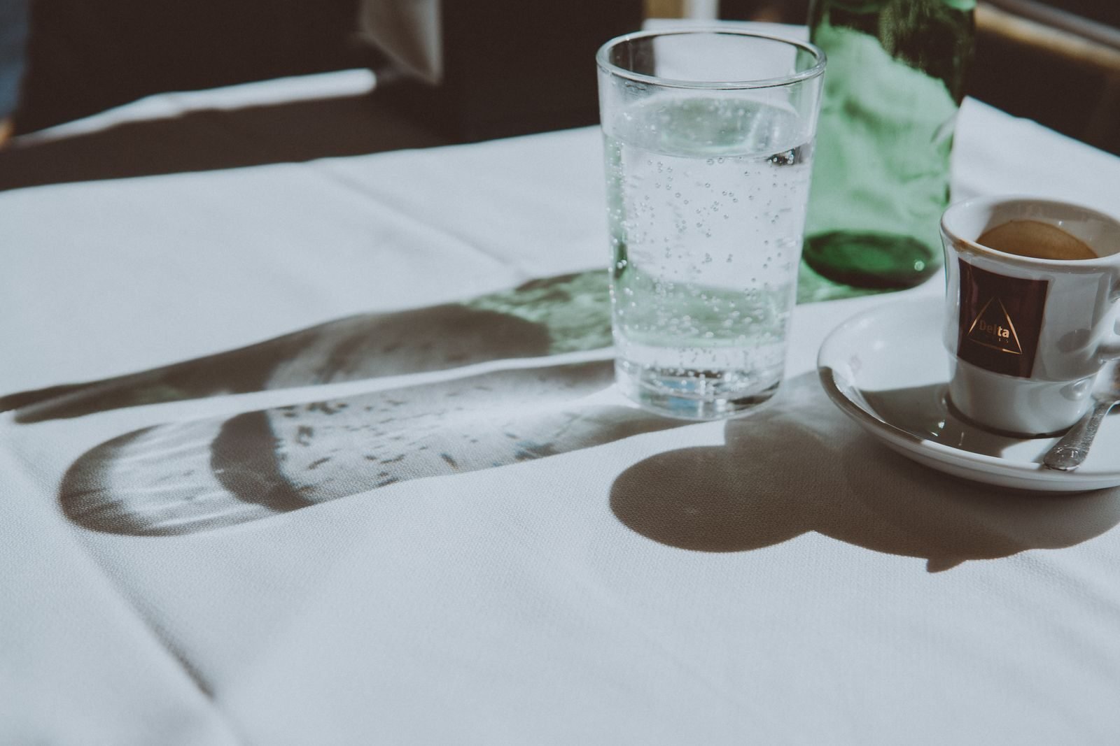 Espresso and sparkling water on a sunny table before fasted running