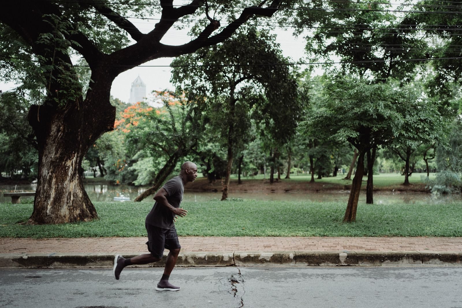 Corredor entrenando en un parque con árboles