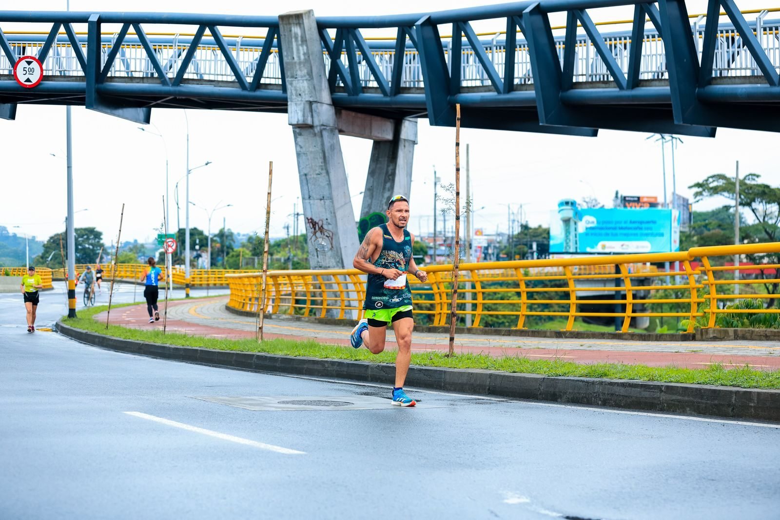 Hombre corriendo un maratón urbano con la ciudad de fondo, buscando un negative split