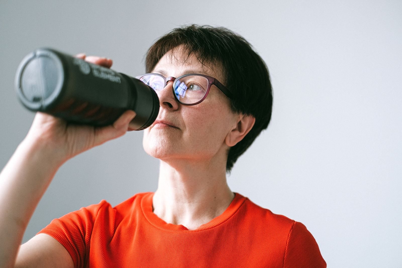 Corredora veterana bebiendo agua de una botella