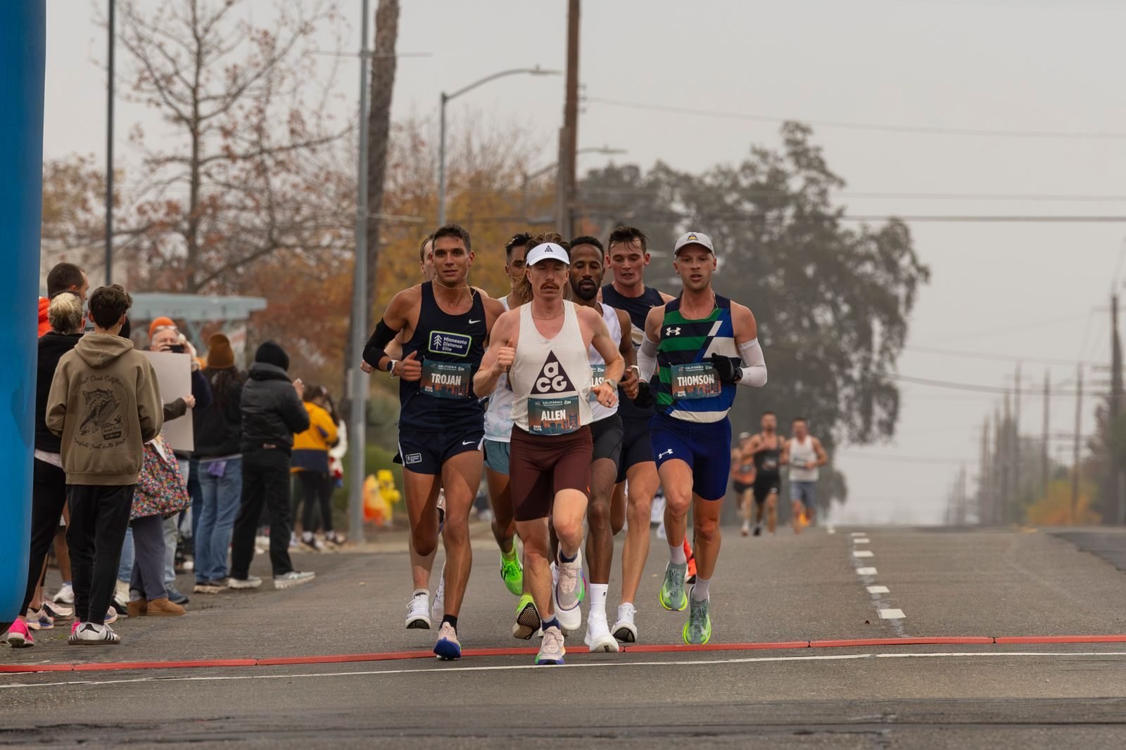 Grupo de corredores en plena maratón en un día nublado