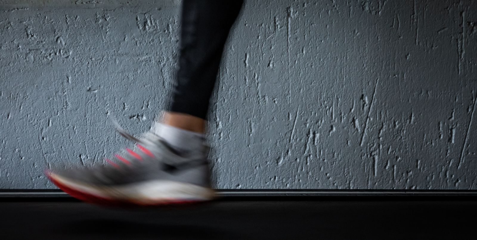 Pie de un corredor en movimiento sobre una cinta de correr