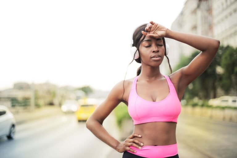 Mujer en ropa deportiva descansando tras correr para perder peso al aire libre