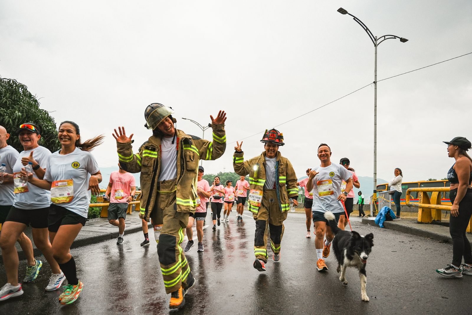 Participantes, entre ellos bomberos, corriendo en una carrera popular como la Cursa de Bombers