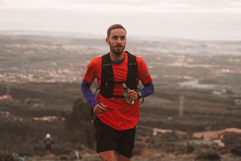 Corredor de trail con camiseta roja y mochila en lo alto de una montaña, imagen ilustrativa de la Cursa del Farell 2026