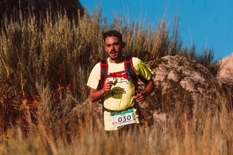 Corredor de trail con mochila entre hierba seca, imagen ilustrativa de la Cursarroca 2026