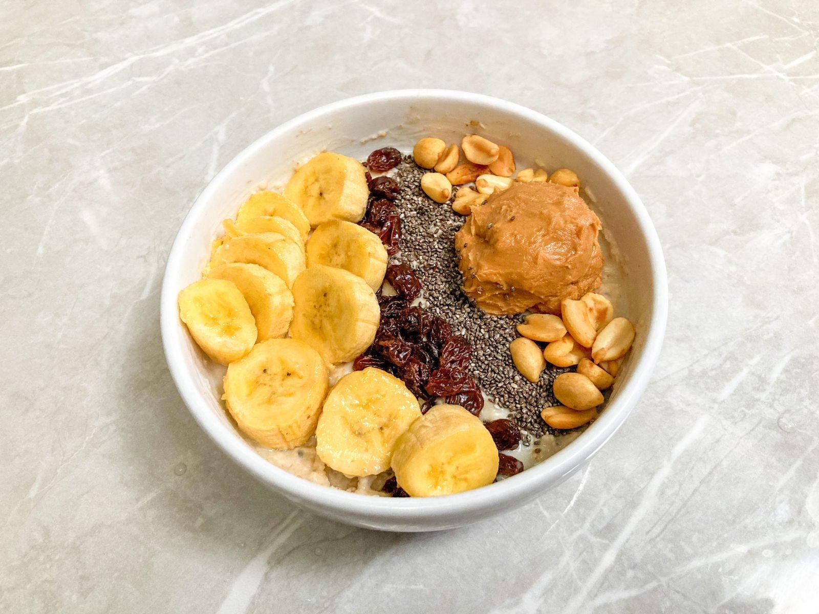 Bol de desayuno con plátano, frutos secos y cacahuete, rico en hidratos