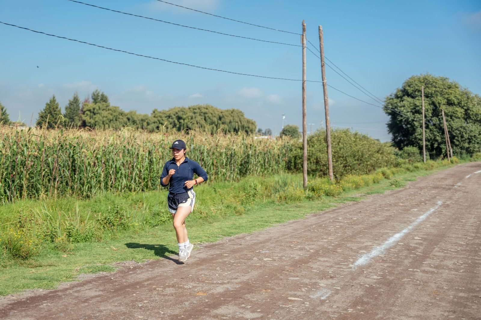 Woman running on a dirt road in summer