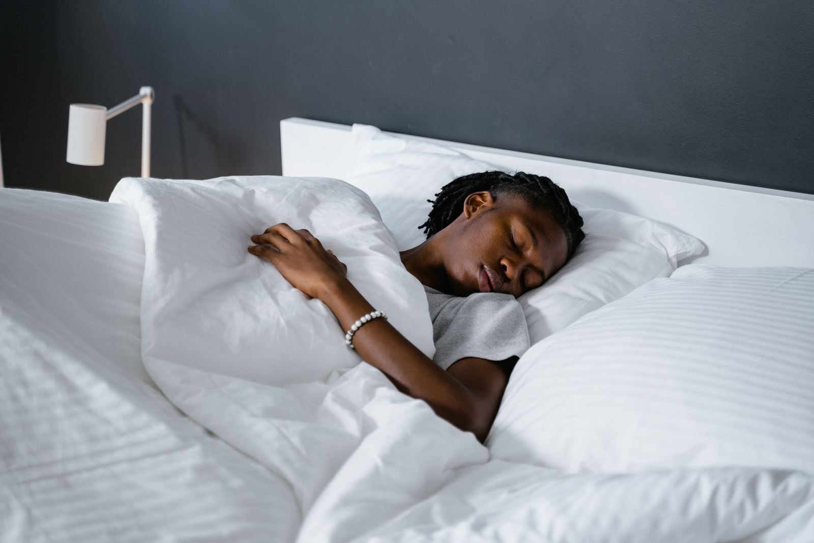 Hombre durmiendo bajo una manta blanca
