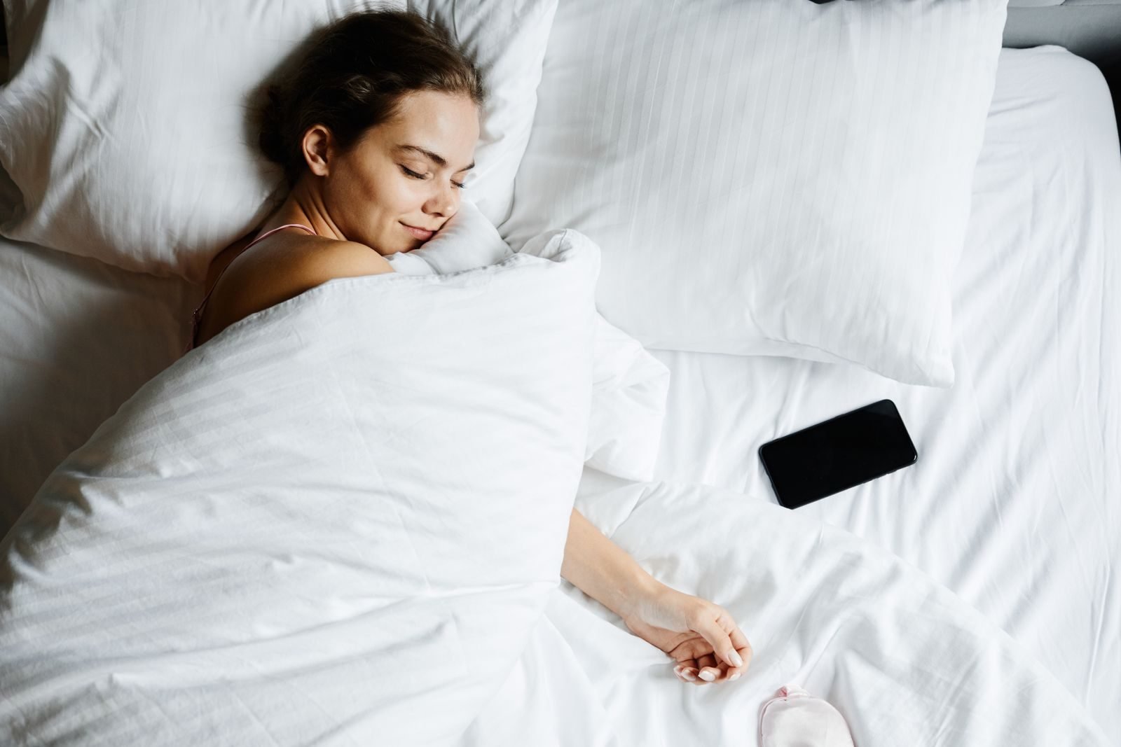 Mujer durmiendo en la cama, el descanso que ayuda a evitar el sobreentrenamiento