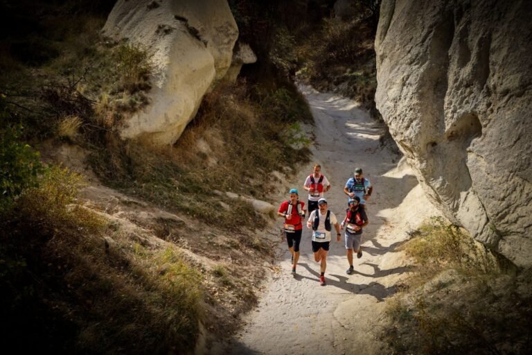 Group of runners descending a rocky trail in a mountain race