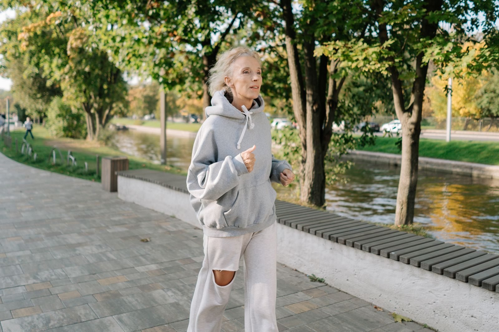 Mujer mayor trotando junto a un canal, una buena forma de empezar a correr