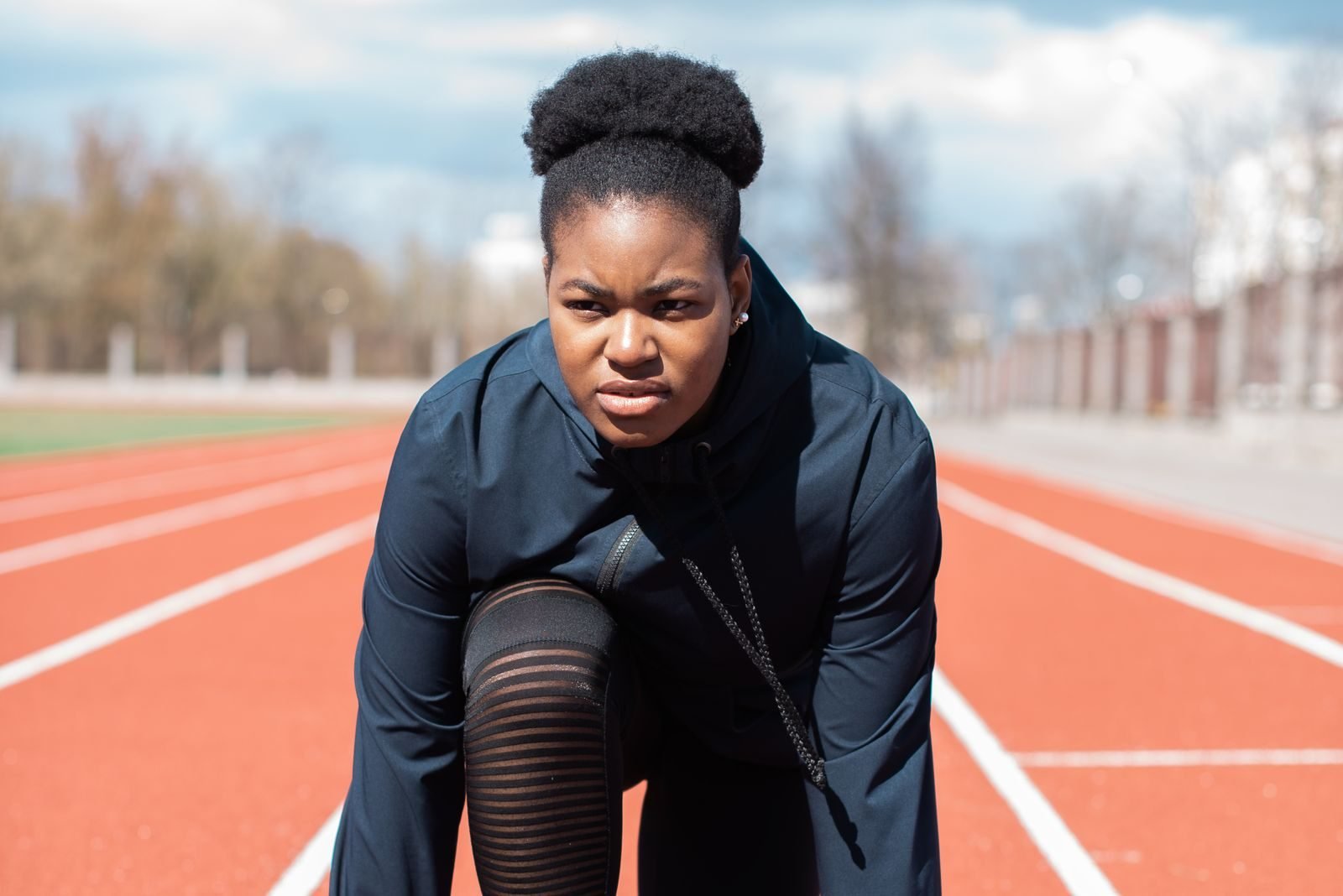 Woman getting ready on a track for a session that will add to her calories burned running