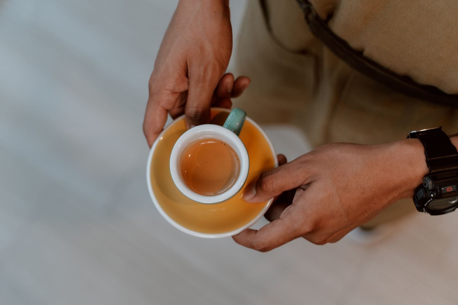Persona sujetando una taza de espresso antes de entrenar, primer paso de cafeína y bicarbonato