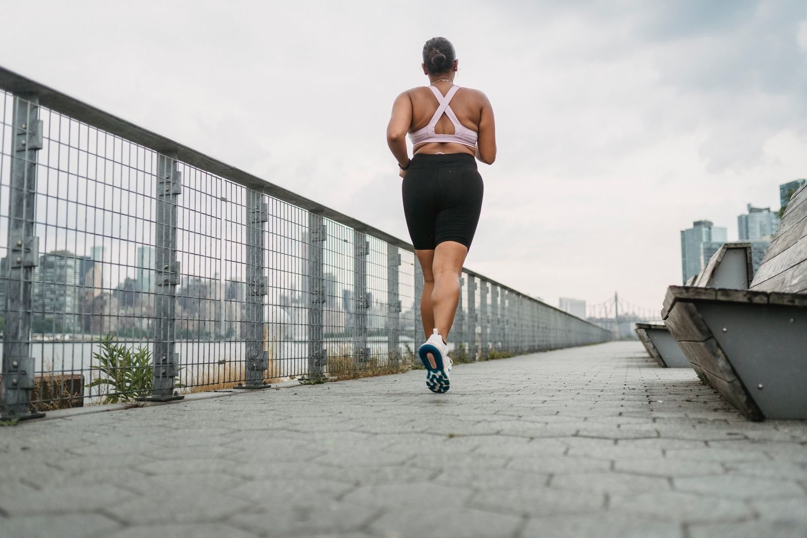Mujer corriendo por un paseo junto al río, ideal para un fartlek