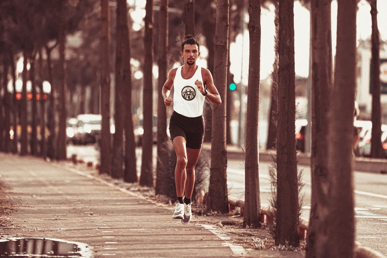 Corredor haciendo fartlek por un paseo arbolado