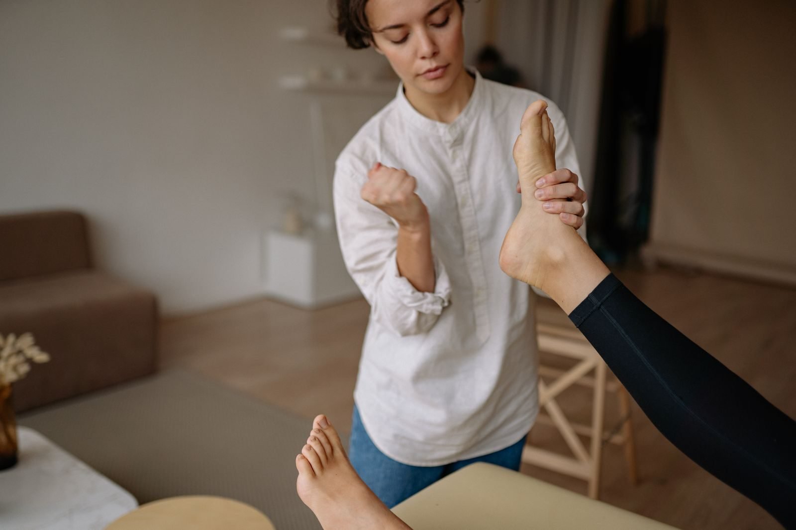 Fisioterapeuta estirando el pie de una paciente con fascitis plantar