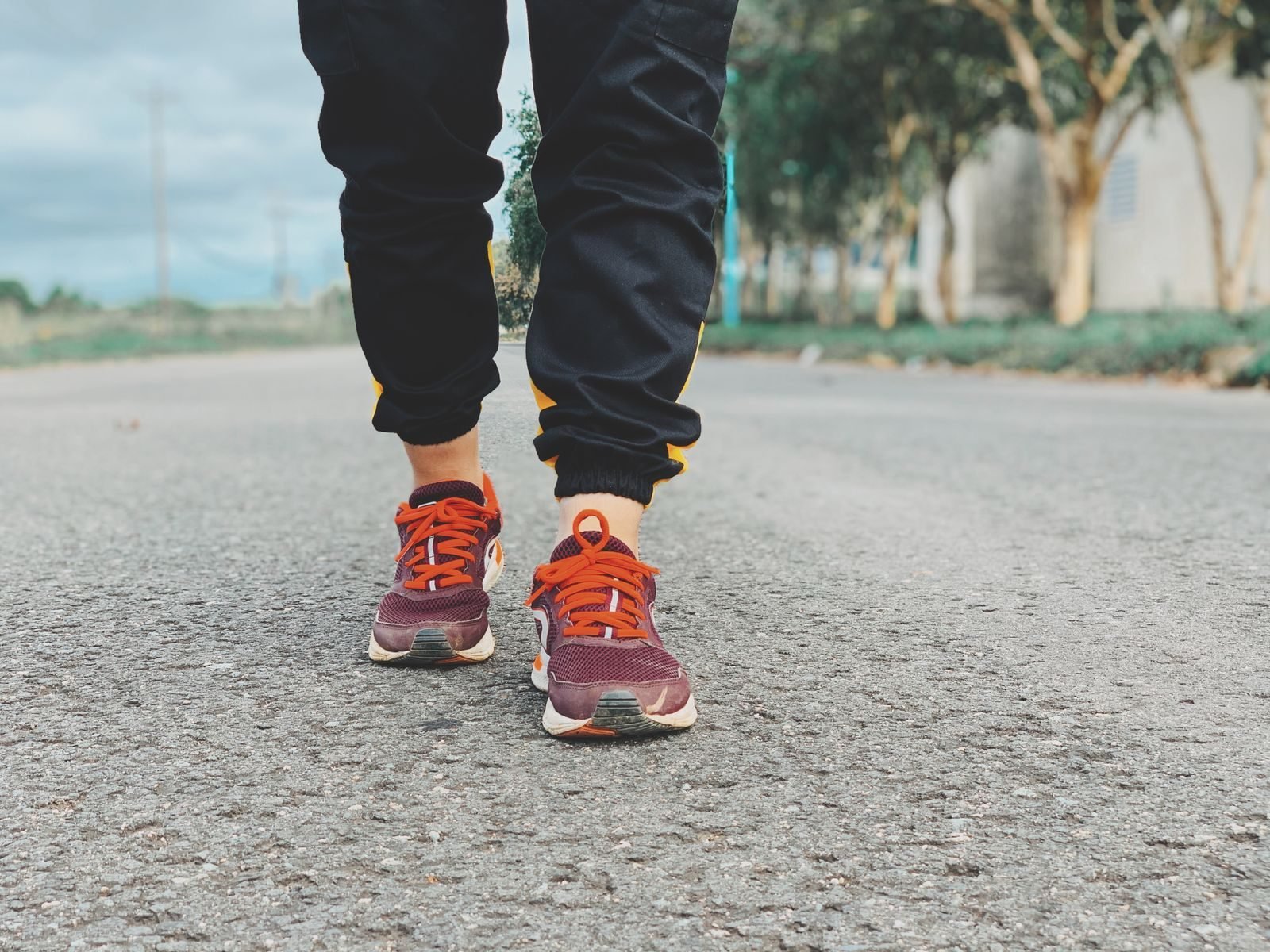Feet in running shoes standing on asphalt
