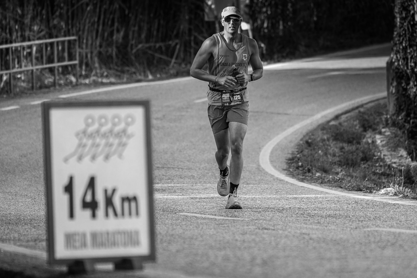 Runner passing the 14 km sign in a half marathon