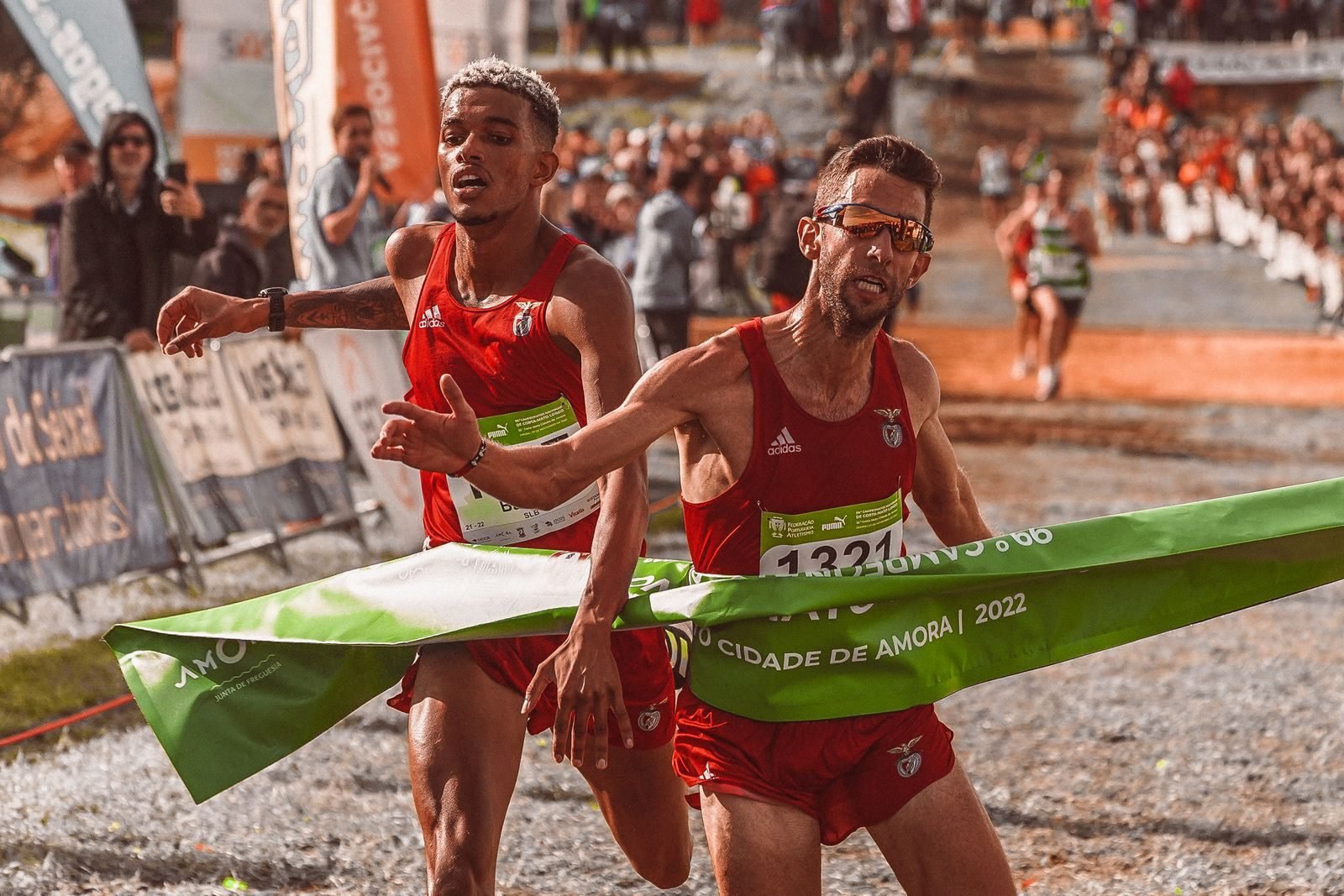 Two athletes crossing a marathon finish line after hitting the wall