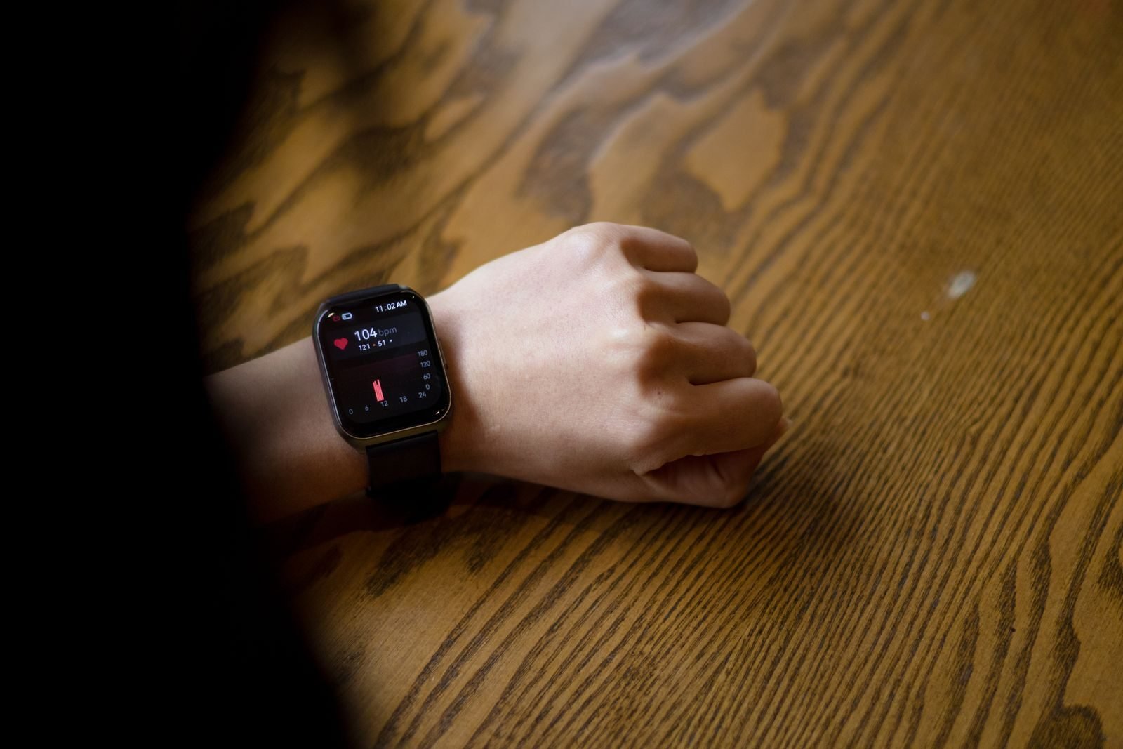 Smartwatch showing 104 beats per minute on a wrist