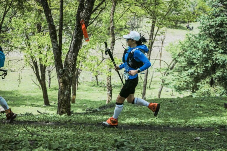 Corredora de trail con bastones por un bosque verde, imagen ilustrativa de la Històric Trail Calafell 2026