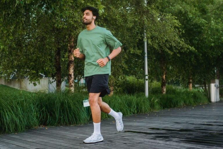 Young man jogging at an easy pace in a green park