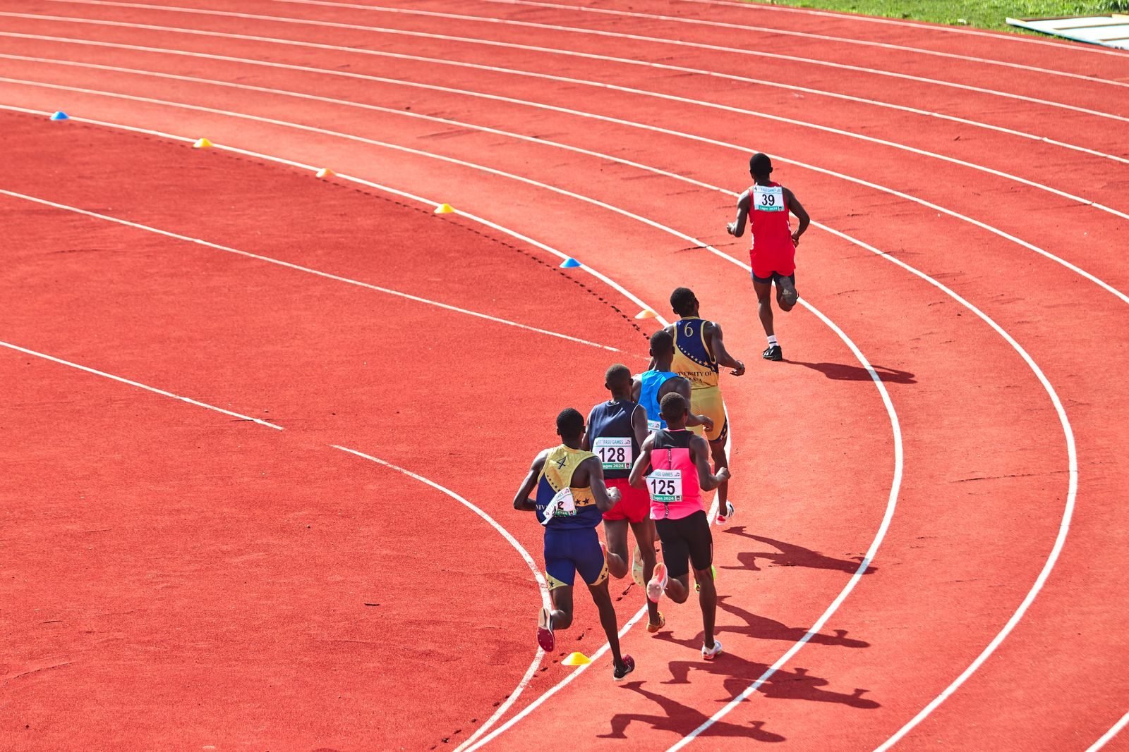 Group of athletes running intervals on the bend of a track, training for a sub-50 10K