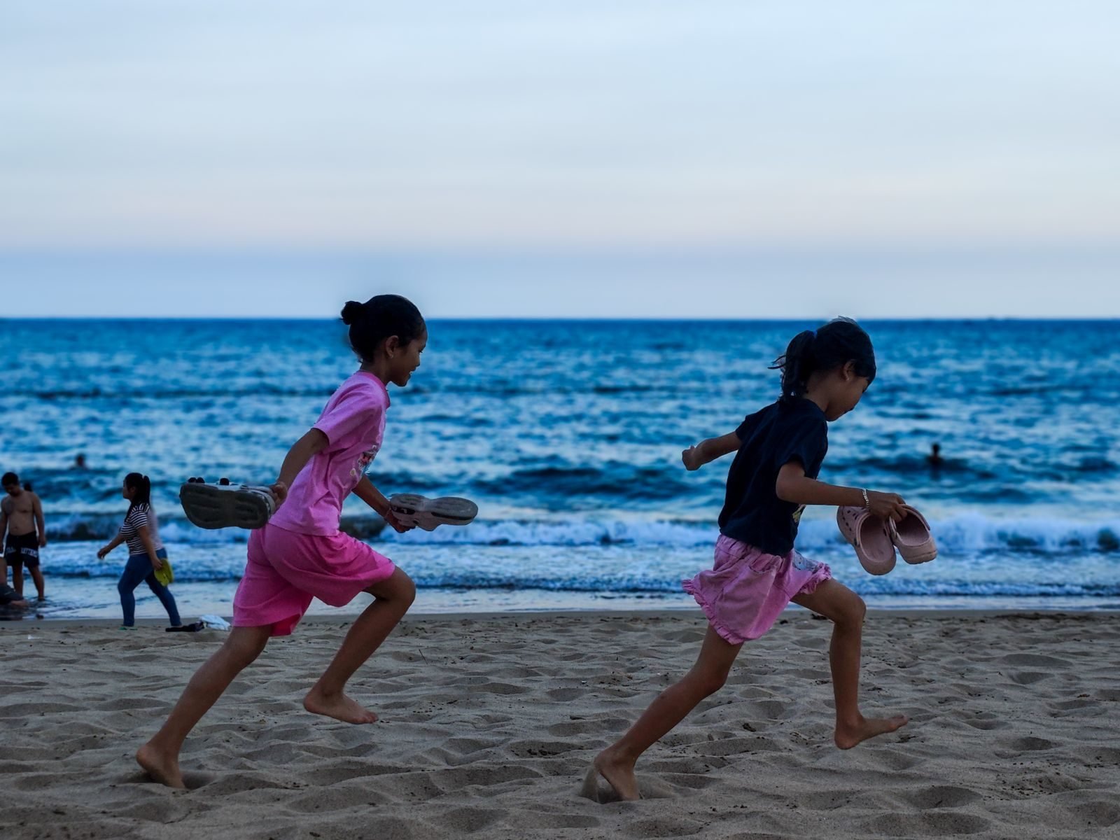 Children running on the beach at sunset