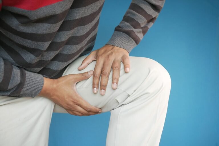 Man holding his knee with both hands because of knee pain from running