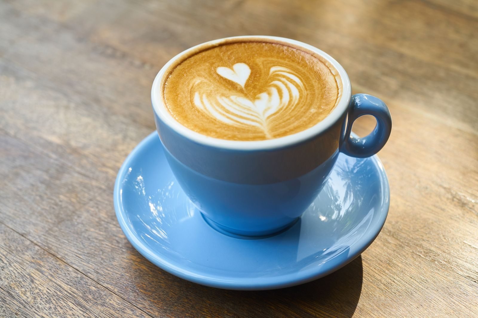 Latte with heart art in a blue cup