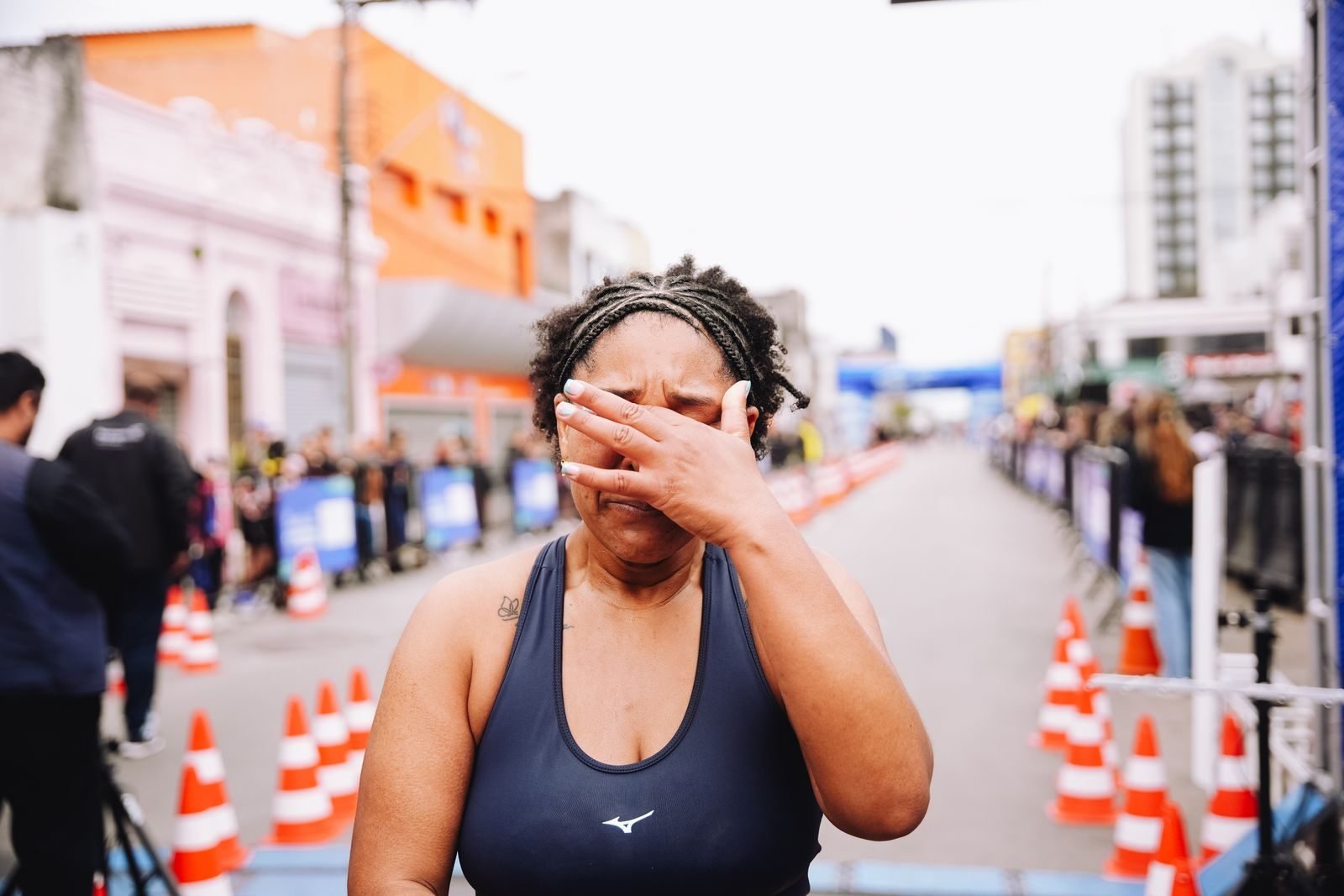 Corredora llegando a meta con gesto de alivio y cansancio