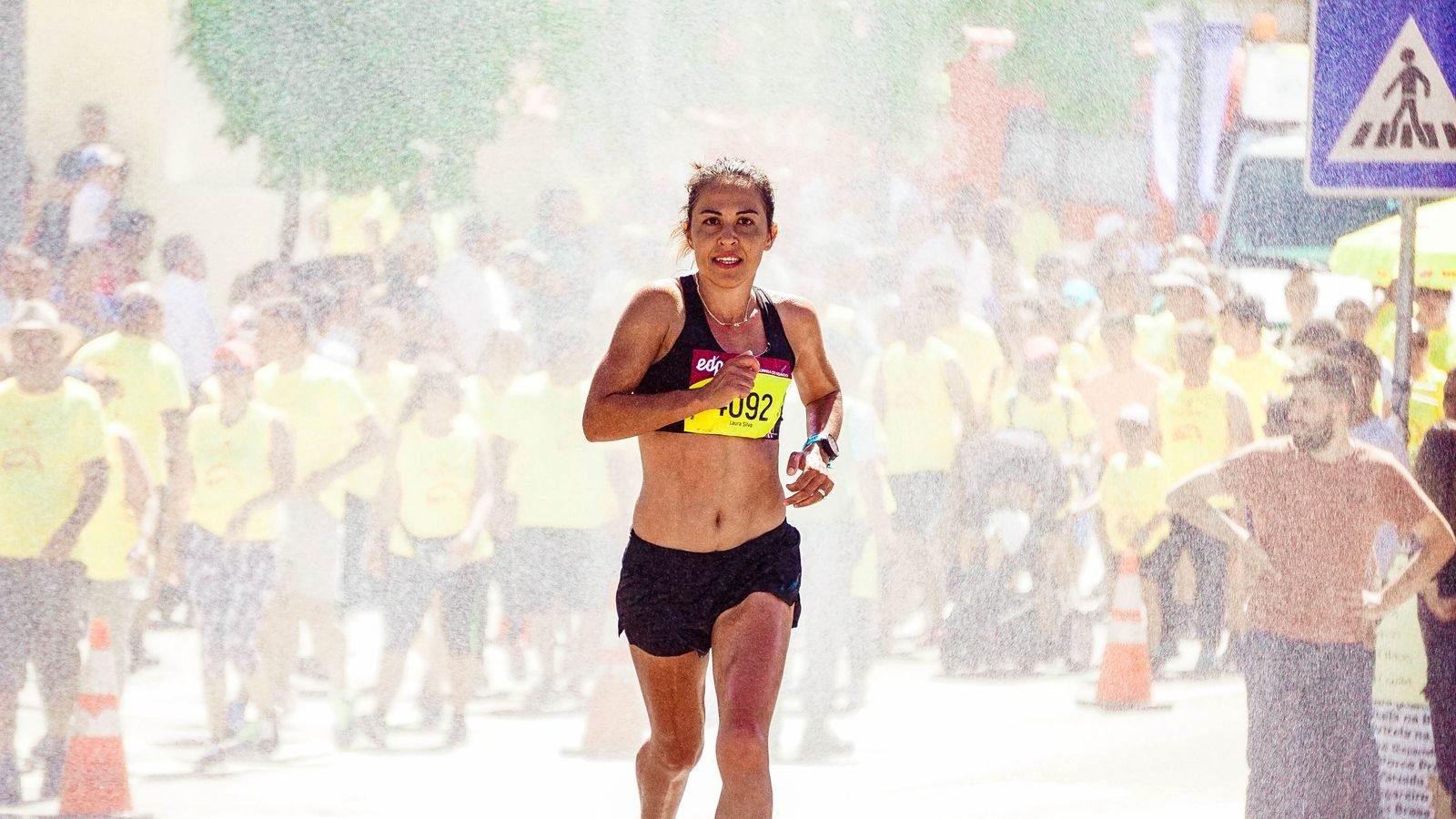 Athlete running a marathon with a cheering crowd, calories burned running