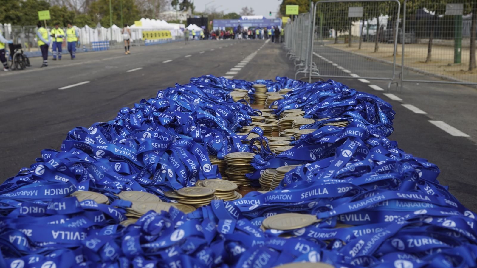 Stack of medals with blue ribbons at a marathon finish