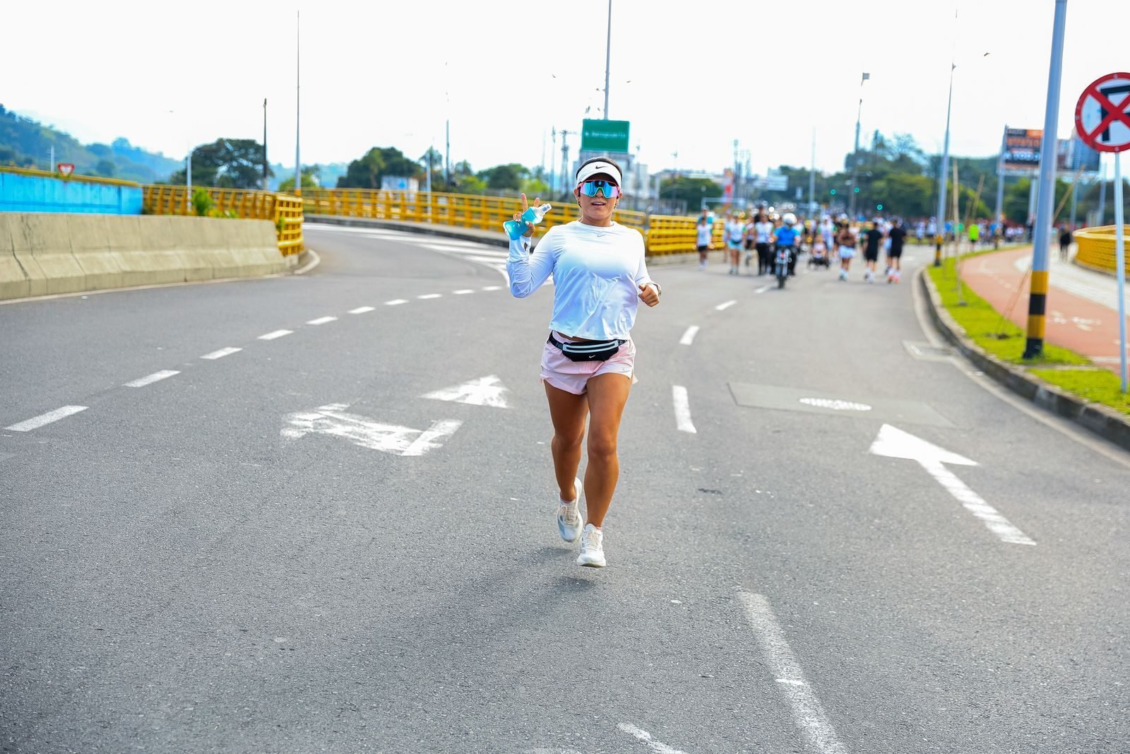 Corredora en una media maratón por una carretera urbana a pleno sol, distancia del récord del mundo de media maratón