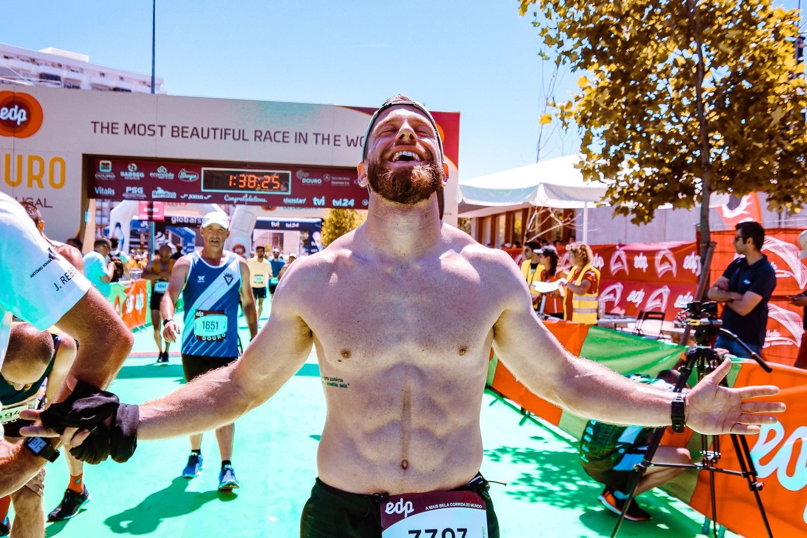 Corredor celebrando en la meta de un maratón tras completar su plan de entrenamiento maratón