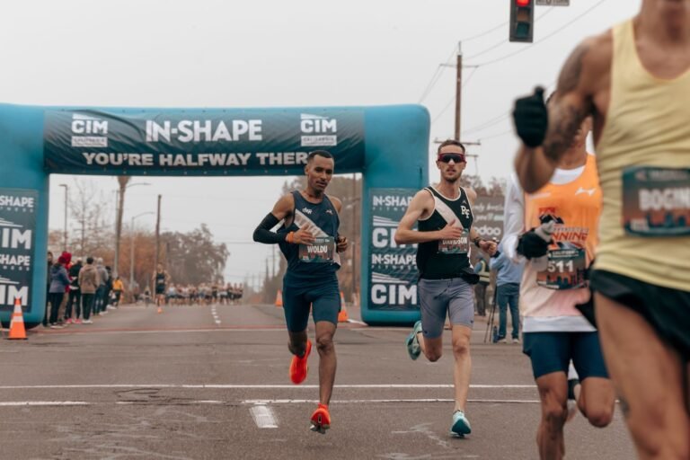 Runners passing under the arch of a road race, illustrative photo for Mitja Marató de Sitges 2027