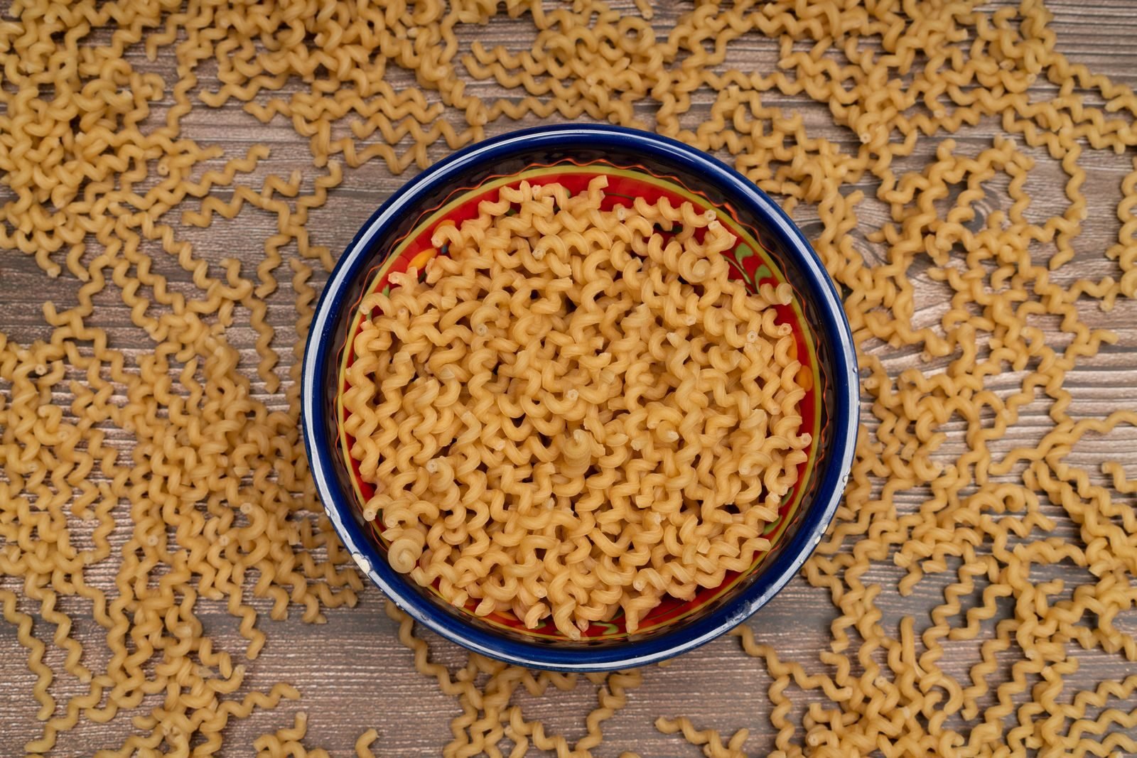 Cuenco de pasta cruda sobre una mesa de madera